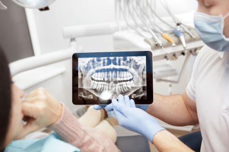Arzt zeigt Röntgenbild auf iPad